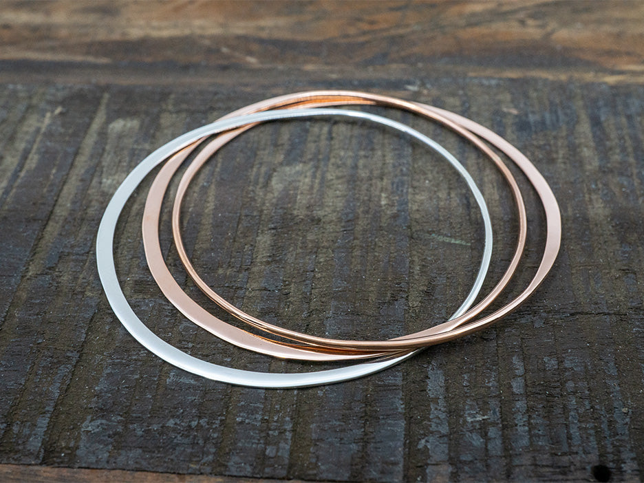 intertwined copper and silver bangle bracelets