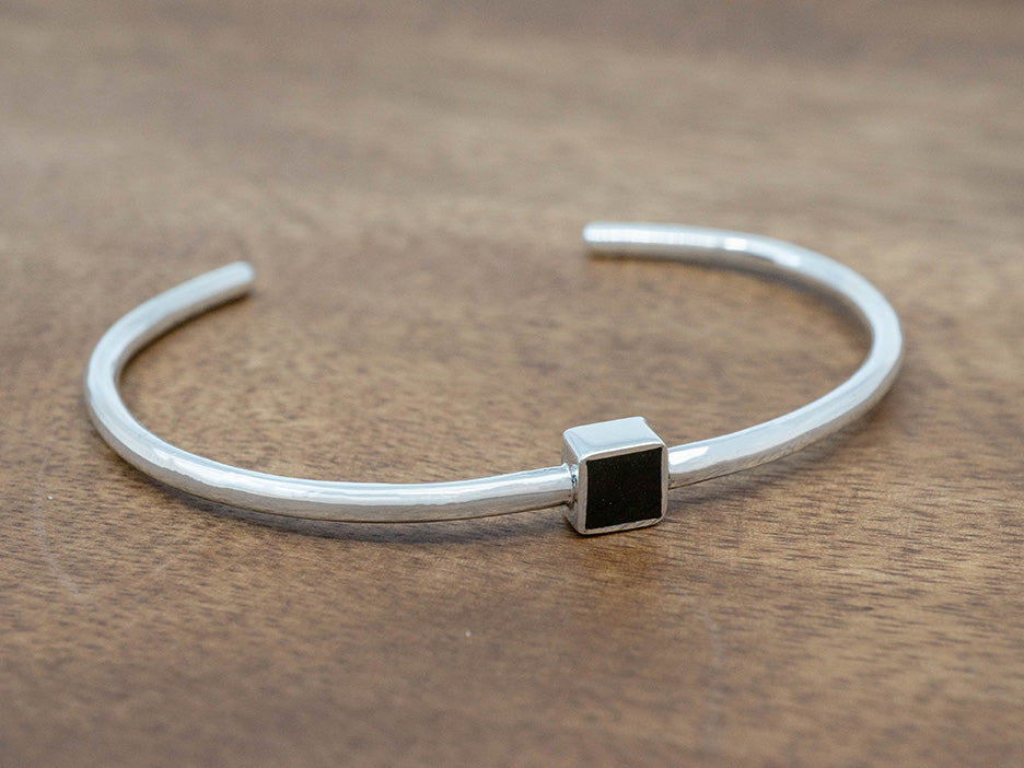 a simple silver cuff with a black enamel square in the center