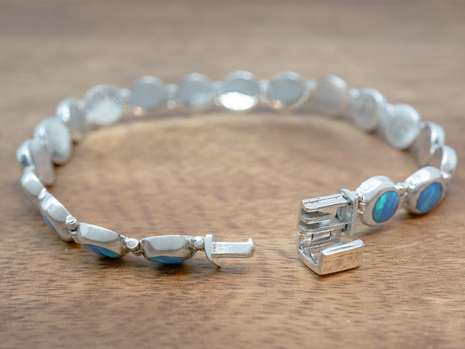 a dainty bracelet of linked blue opal cabochons set in sterling silver.