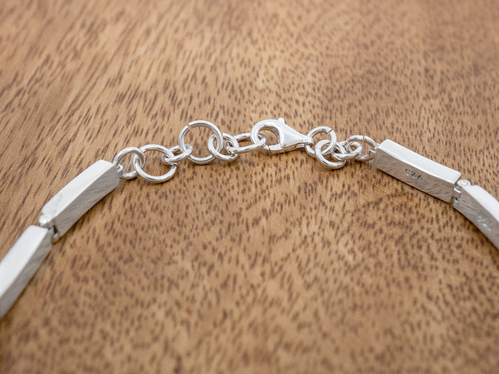 A sterling silver linked bracelet toggle clasp.
