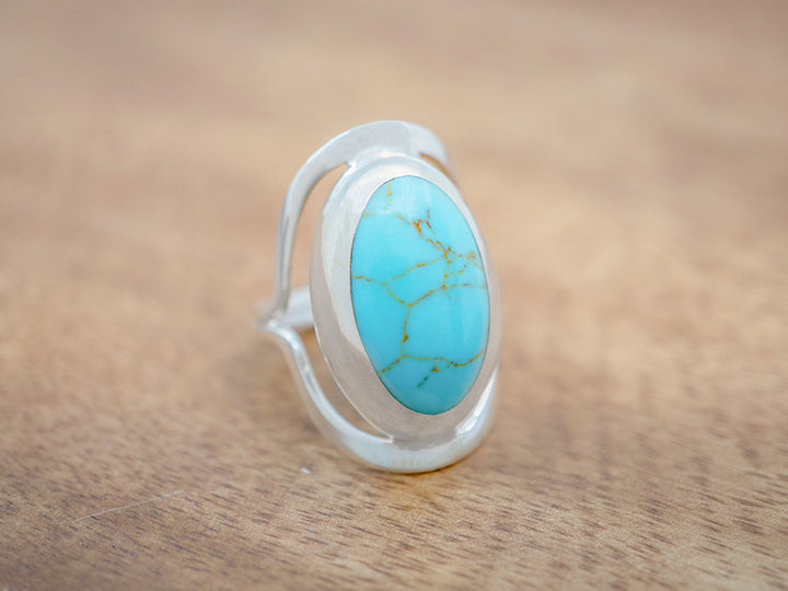 A large, oval sterling silver statement ring with a turquoise stone in the center.