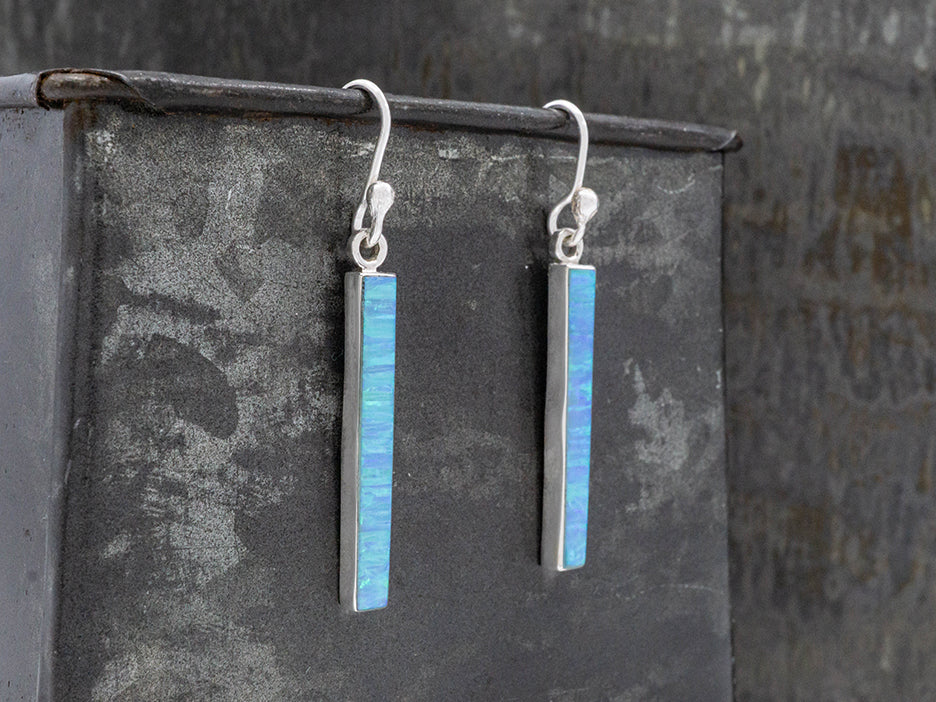 Each earring is a vertical bar of light blue opal set in sterling silver on a hook.