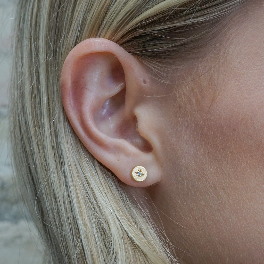Tiny gold-filled disc studs with a cubic zirconia star in the center.