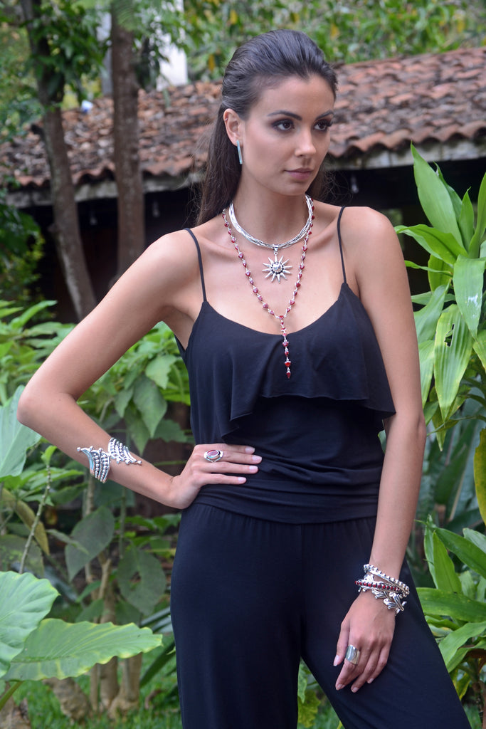 A model wearing A sterling silver lariat necklace made with teardrop and trillion cut red jasper stones, as well as other sterling silver jewelry.