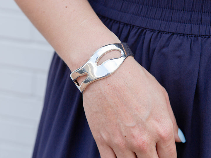 Silver bracelet on a wrist with a blurred background