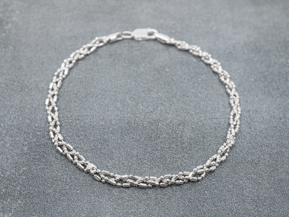 Silver chain bracelet on a gray surface