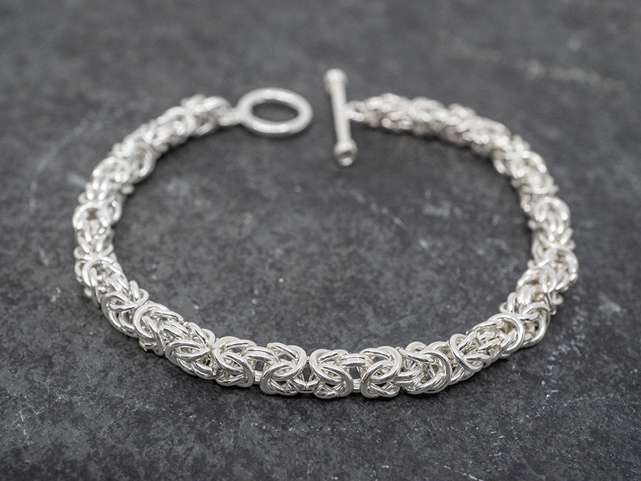 Intricate silver bracelet on a dark gray background