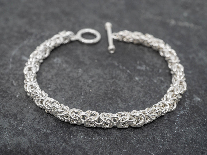 Intricate silver bracelet on a dark gray background