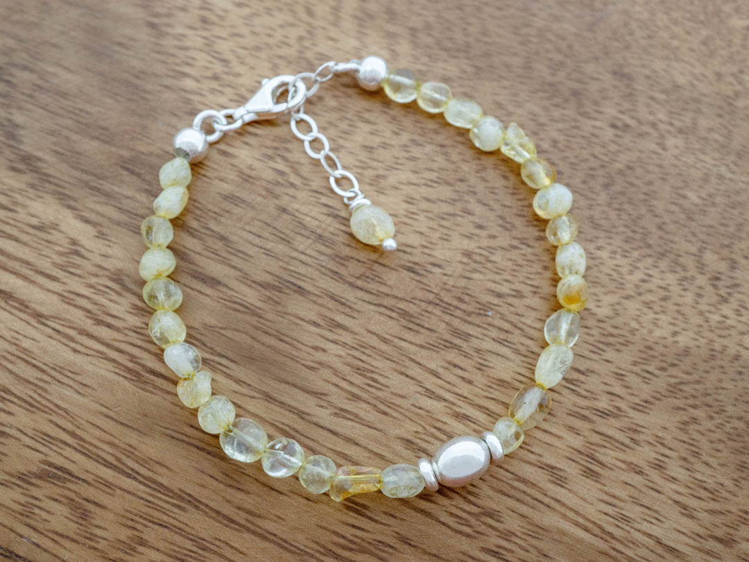 Beaded bracelet with yellow stones on a wooden surface