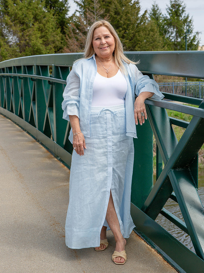 woman wearing a light blue maxi skirt with a front slit and matching blouse
