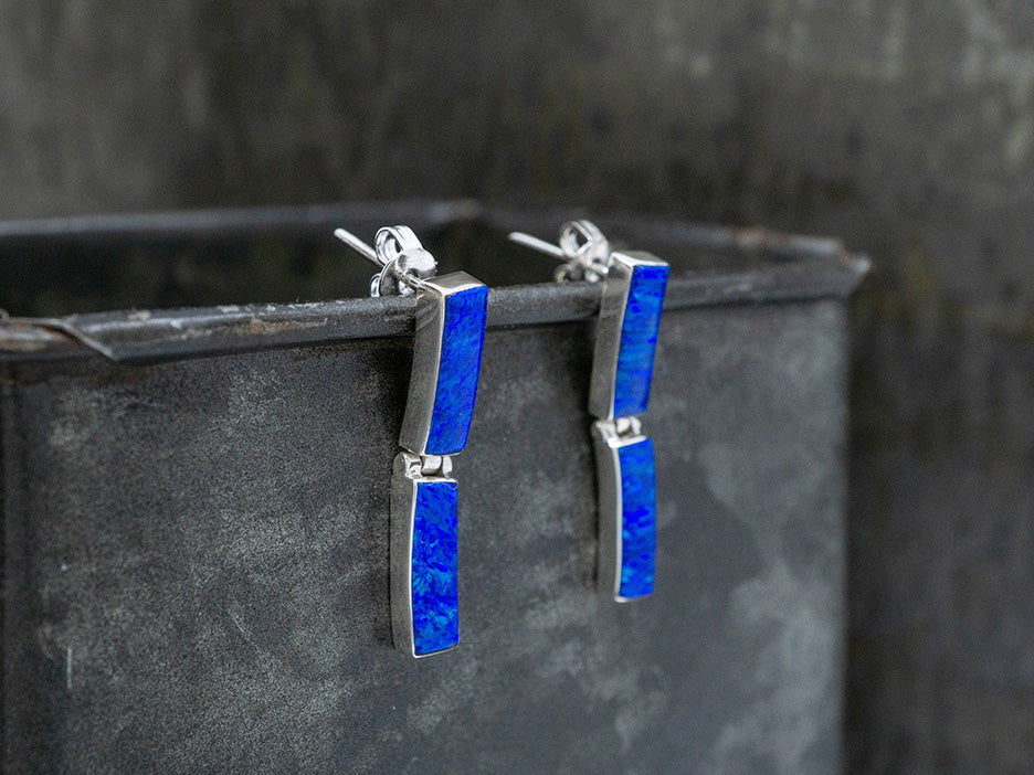 A pair of sterling silver post earrings with 2 rectangular links of dark blue opal.