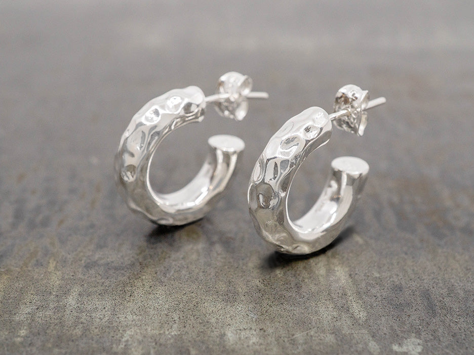 a pair of hammered silver hoop earrings