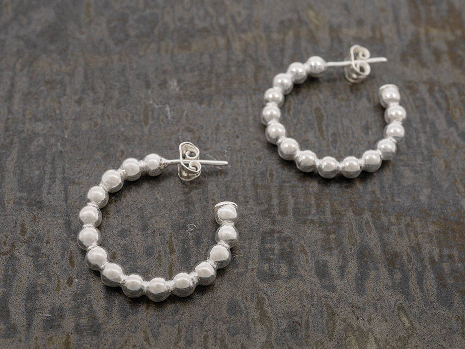 a pair of sterling silver beaded hoops