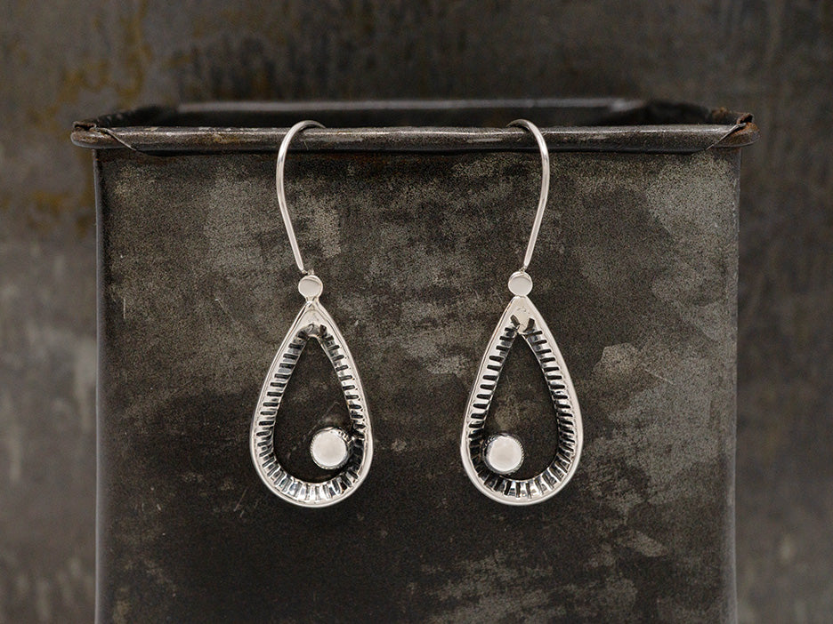 Sterling silver open teardrop earrings with a raked, oxidized finish and an off-center bead in the middle.