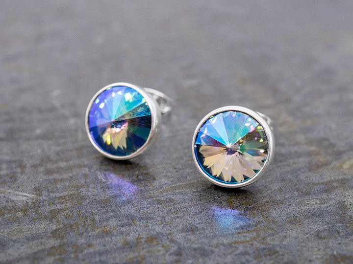 Round stud earrings with colorful crystals on a gray surface