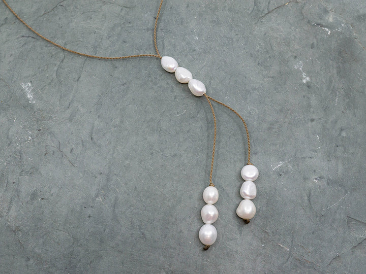 Pearl necklace on a textured gray surface