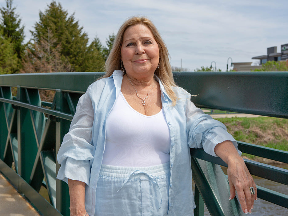woman wearing a light blue outfit and pearl necklace