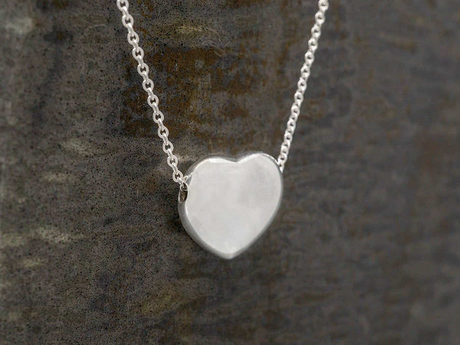 A silver heart on a chain.