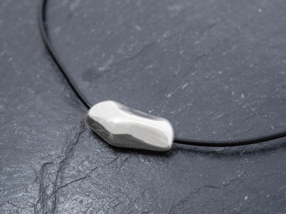 Abstract silver pendant on a black cord