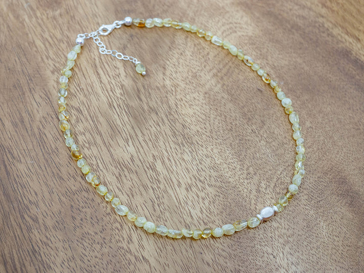Necklace with yellow stone beads on a wooden surface