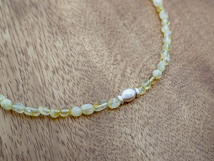 Necklace with yellow stone beads on a wooden surface
