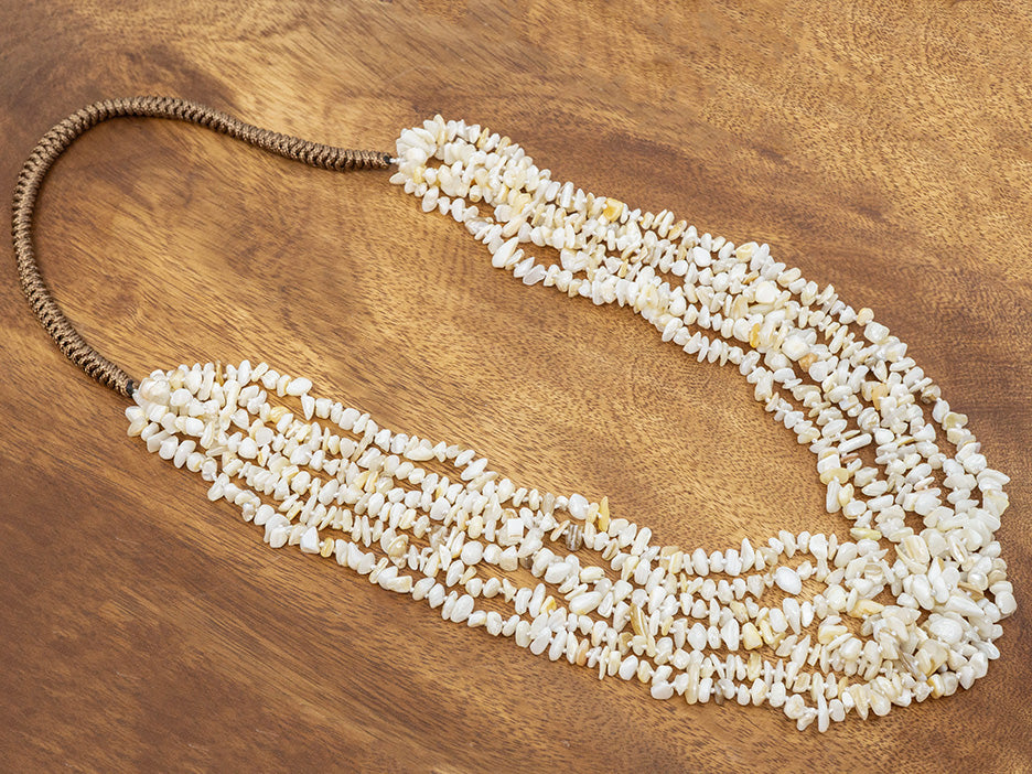 White beaded necklace on a wooden surface