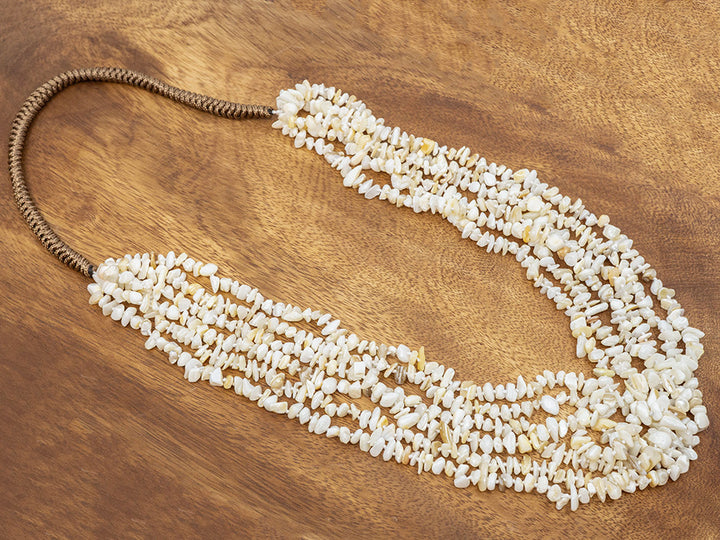 White beaded necklace on a wooden surface