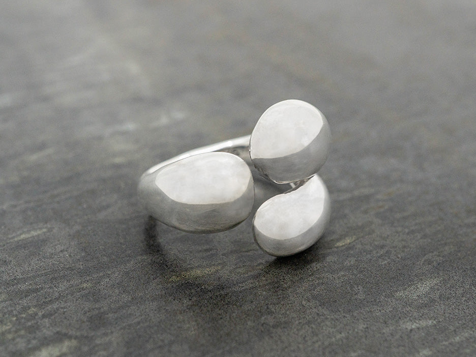 A sterling silver ring with a unique design featuring multiple rounded tines.
