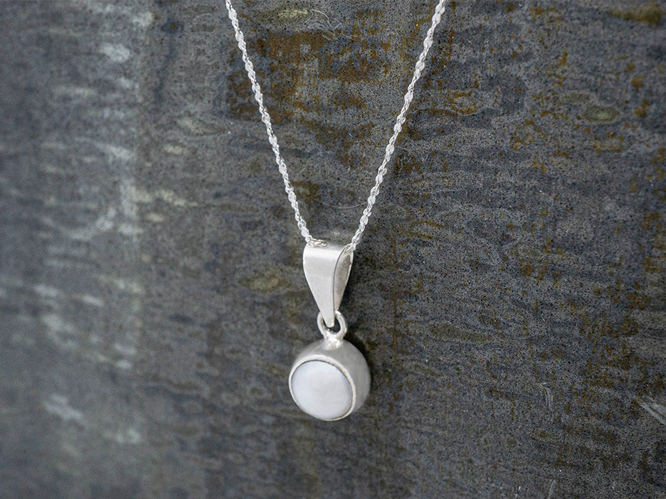 A pearl pendant hanging on A dainty sterling silver rope cut chain.