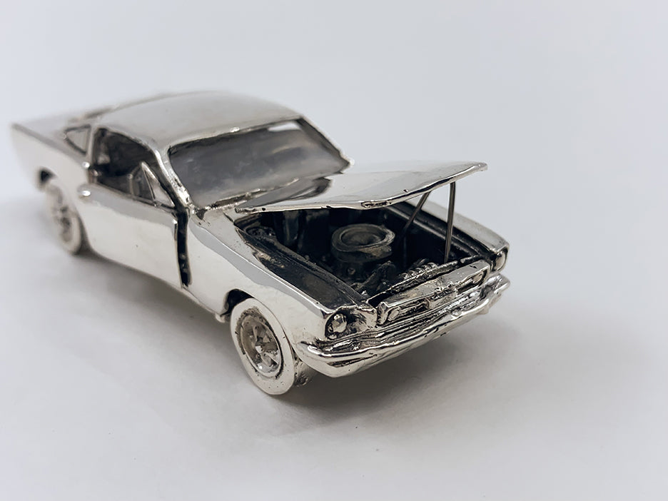 Sterling silver die-cast model of a 1965 Ford Mustang with the hood open.