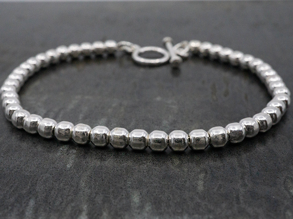 A sterling silver beaded bracelet with a toggle closure.