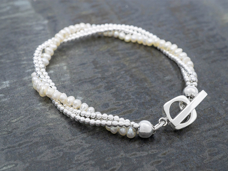 a three stand pearl and silver bracelet with a sterling silver toggle
