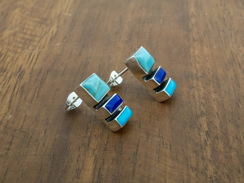 A sterling silver post earring featuring three blue stones: turquoise, cobalt and electric blue.