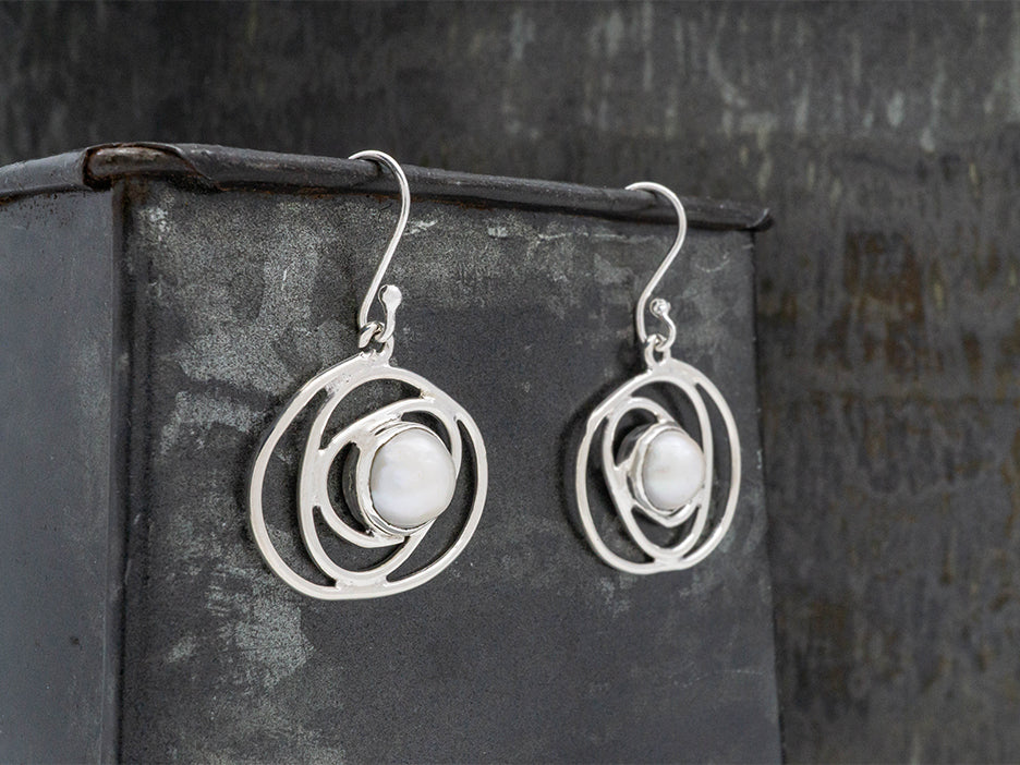 sterling silver hook earrings featuring a silver swirl with a pearl in the center