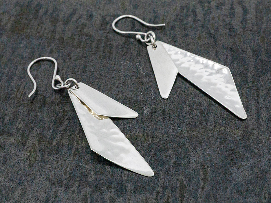 A two-piece earring made with two sterling silver quadrilaterals, one hammered and one smooth.