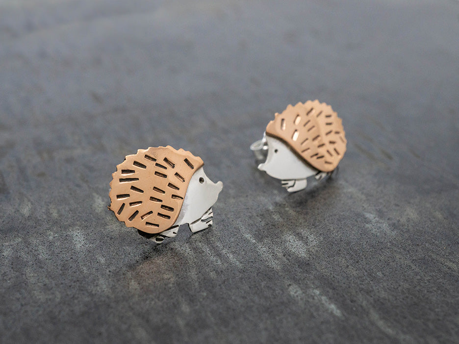 Copper and silver hedgehog earrings on post.