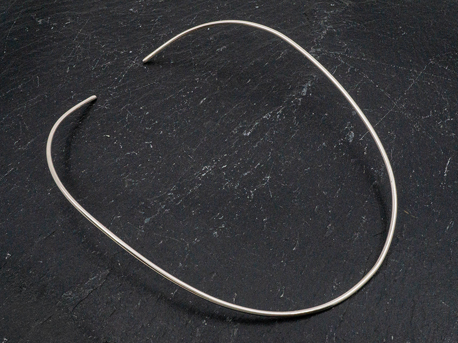 A flexible sterling silver choker that is made to conform to the shape of a woman's neck.