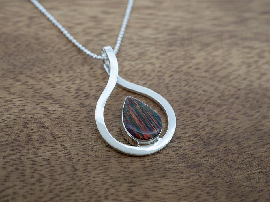 A mexican fire opal necklace featuring an opal teardrop in a sterling silver frame. 