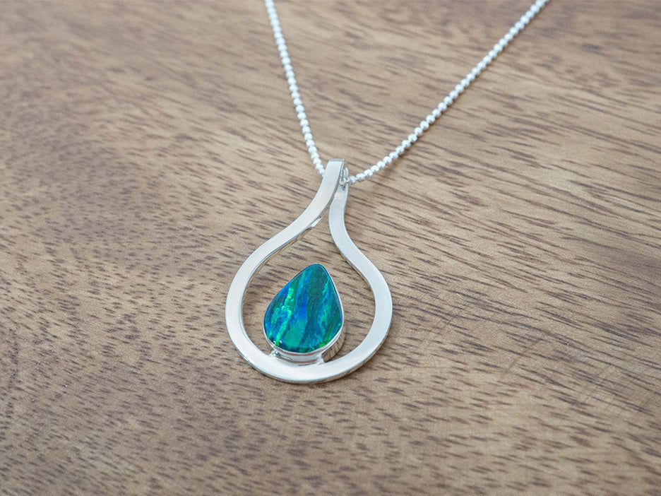 A green opal teardrop pendant in a sterling silver frame.
