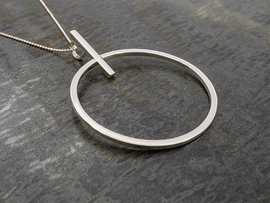 handmade circle pendant on pendulum made of sterling silver.