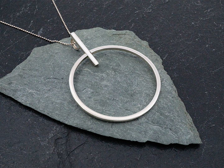 Sterling silver circle pendant with bar.