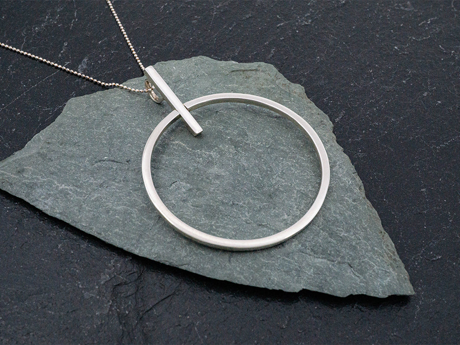 Sterling silver circle pendant with bar.